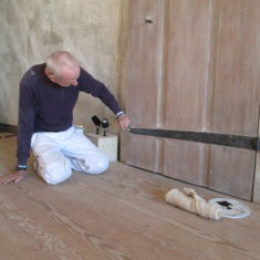Specialist decorator Jeremy Kneller working on a door in the Retainers Gallery in 2018