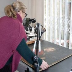 Melanie examining a painting under microscope Melanie examining a painting under microscope
